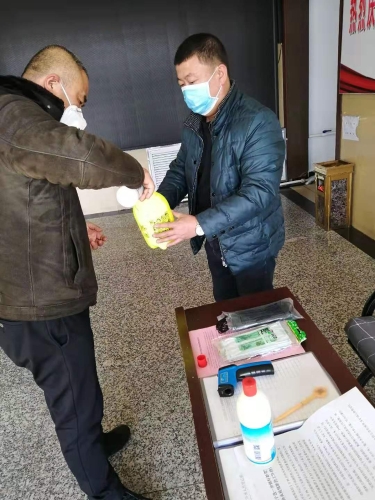 七台河公司东风矿矿党委副书记王占寒在督导检查防疫工作的同时为单位提供测温仪、消毒液、喷壶等防护用品。图为王占寒（左）正与党员对办公场所进行消毒。（于秀娟摄）